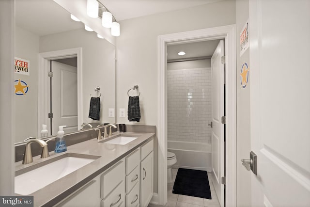 bathroom featuring tile patterned flooring, double vanity, toilet, and a sink