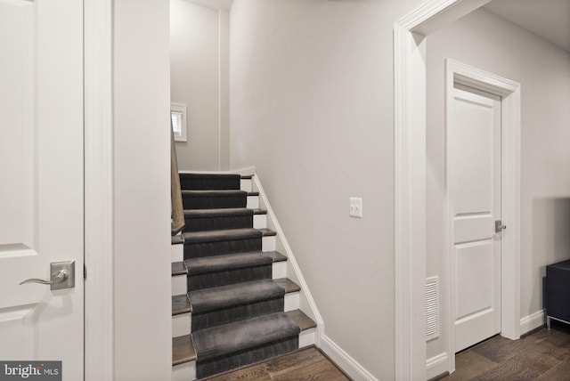 stairs with visible vents, baseboards, and wood finished floors