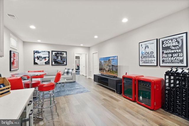 living area featuring recessed lighting, visible vents, and wood finished floors