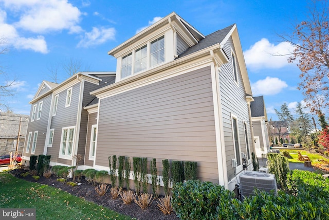 view of side of home with central AC