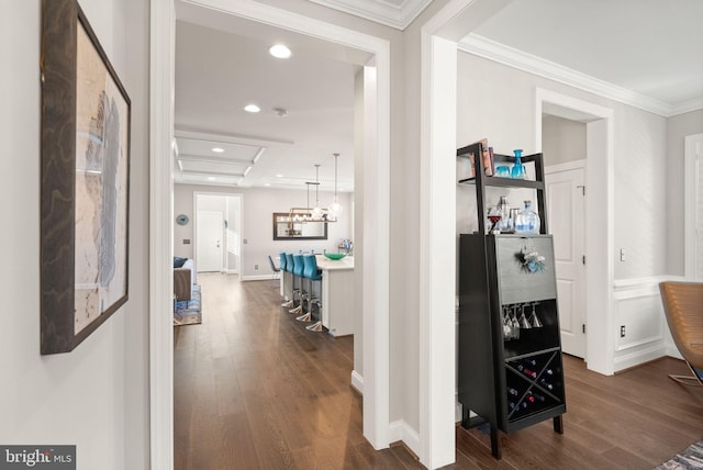 corridor with dark wood-style flooring, recessed lighting, baseboards, and ornamental molding