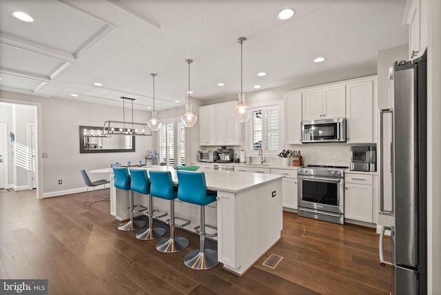 kitchen featuring visible vents, appliances with stainless steel finishes, white cabinets, and dark wood-style flooring