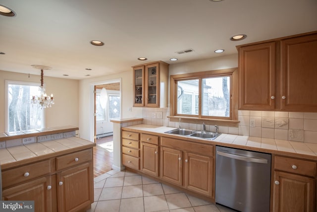 kitchen featuring a sink, visible vents, stainless steel dishwasher, and tile counters