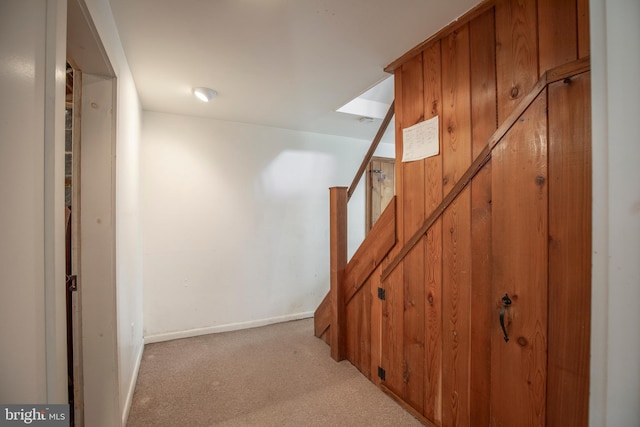 stairway featuring baseboards and carpet