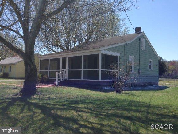 rear view of property with a lawn, a chimney, and a sunroom