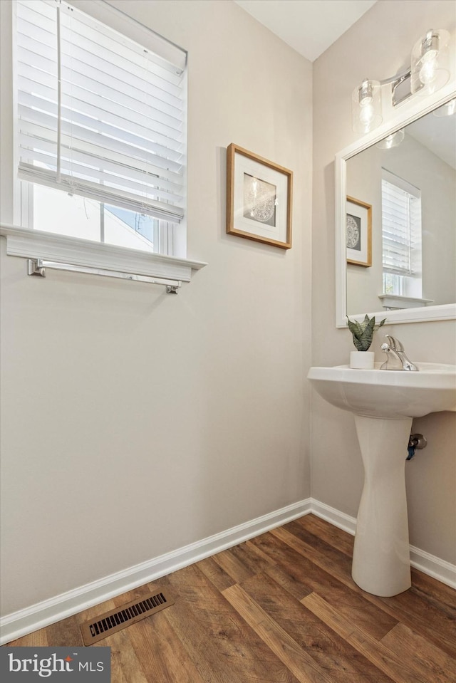 bathroom with visible vents, baseboards, and wood finished floors