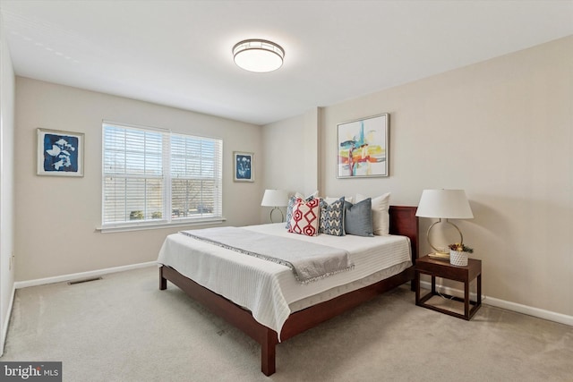 bedroom featuring visible vents, baseboards, and carpet