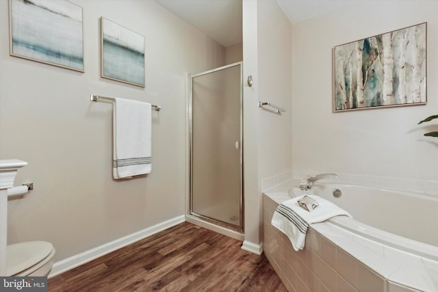 full bath with wood finished floors, baseboards, toilet, a stall shower, and a bath