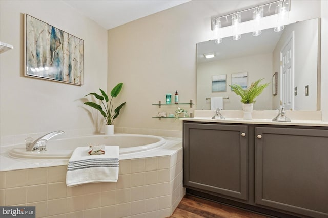 bathroom featuring double vanity, a bath, wood finished floors, and a sink