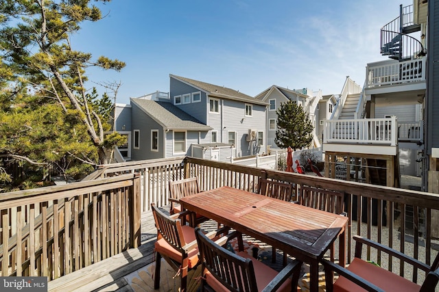 wooden terrace featuring outdoor dining area and a residential view