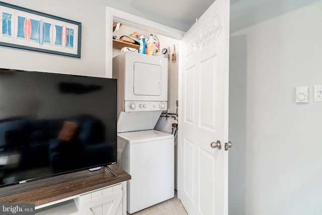 clothes washing area featuring stacked washer / dryer and laundry area