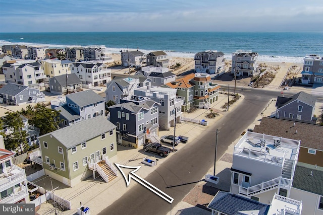 birds eye view of property with a water view and a view of the beach