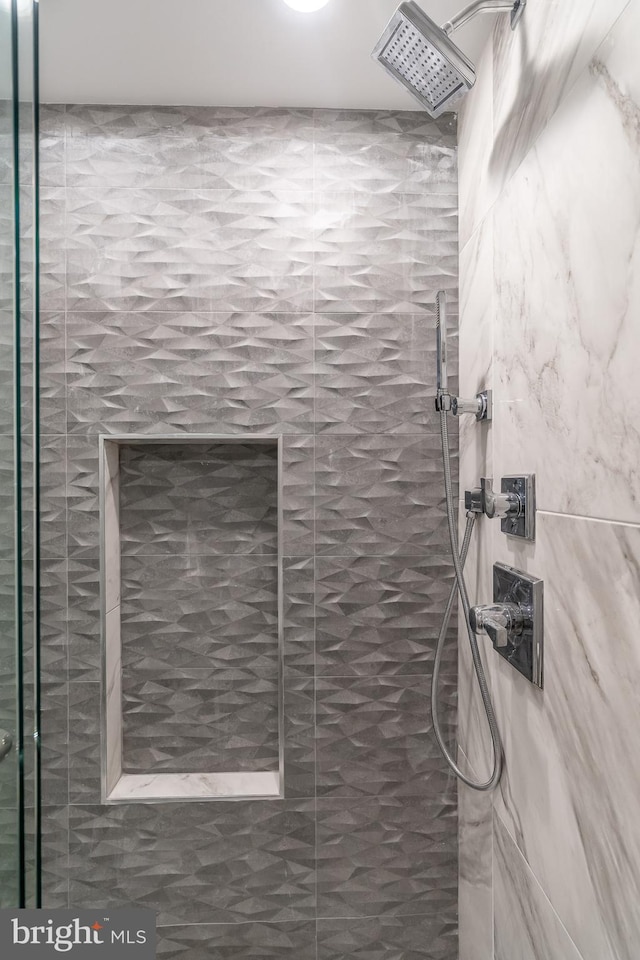 interior details featuring tiled shower