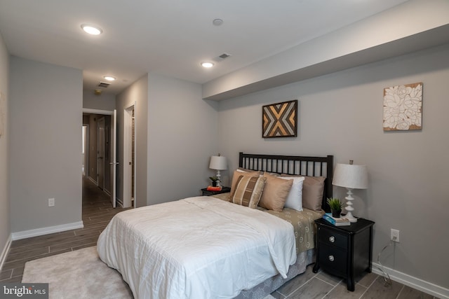 bedroom featuring wood finish floors, visible vents, baseboards, and recessed lighting