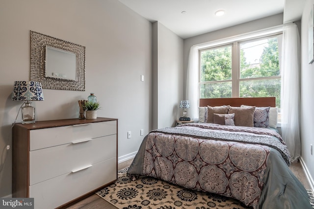 bedroom with baseboards and wood finished floors