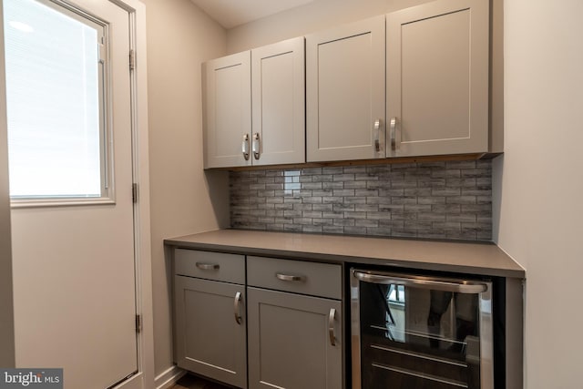 bar featuring backsplash and beverage cooler