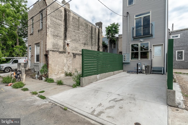 view of property exterior with central AC unit and fence