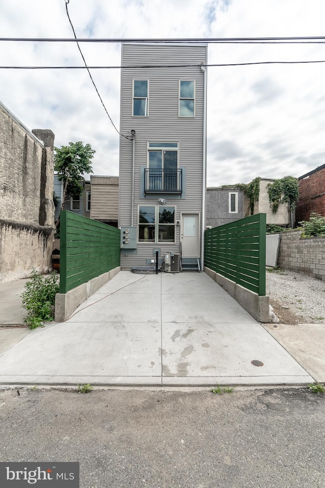 view of front of property featuring a balcony and fence