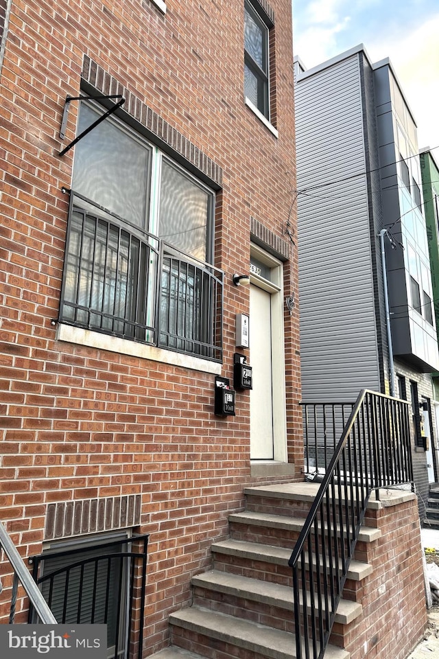 property entrance featuring brick siding