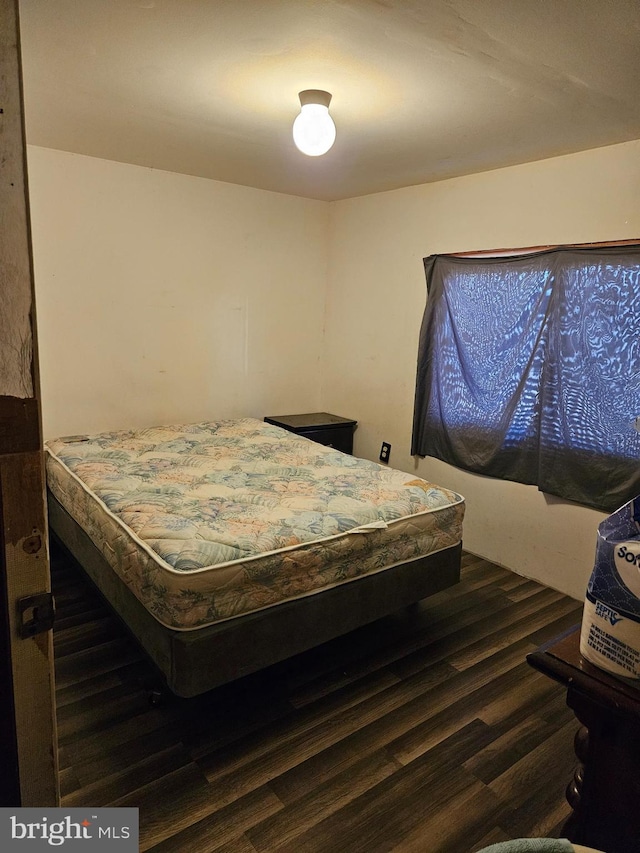 bedroom with dark wood finished floors