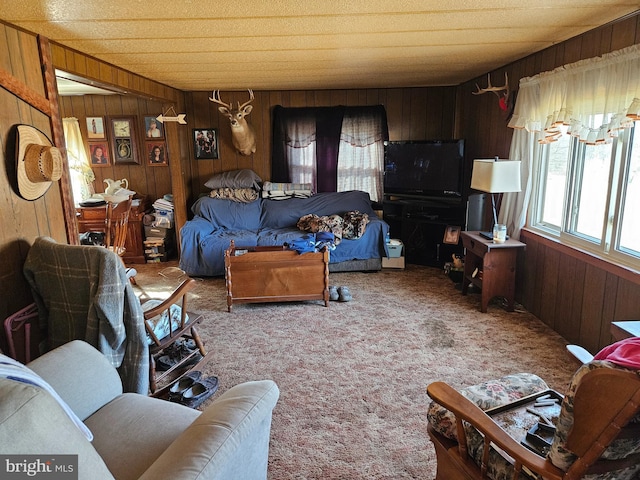 carpeted living area with wood walls