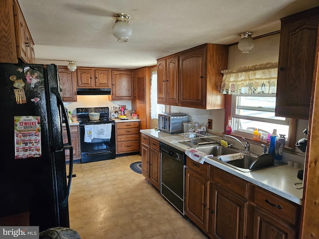 kitchen with light floors, light countertops, range hood, black appliances, and a sink