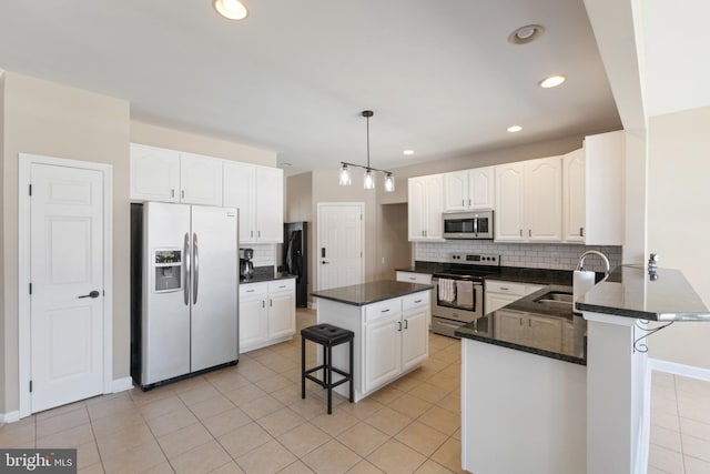 kitchen featuring a sink, a kitchen breakfast bar, white cabinetry, stainless steel appliances, and light tile patterned floors