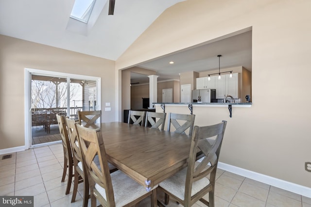 dining area with light tile patterned floors, baseboards, and decorative columns