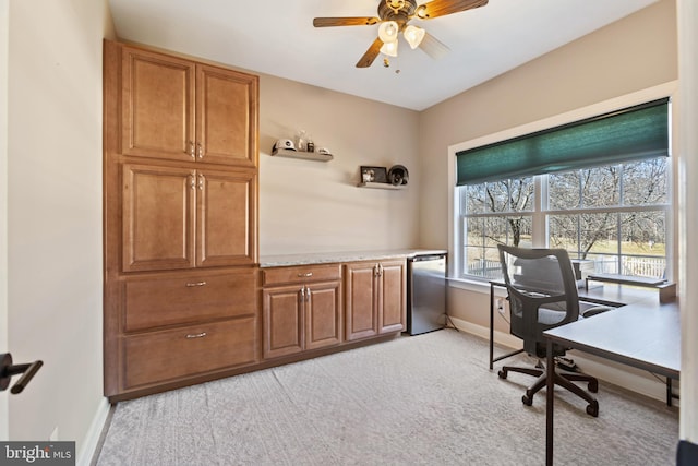 office space featuring baseboards, light colored carpet, and a ceiling fan