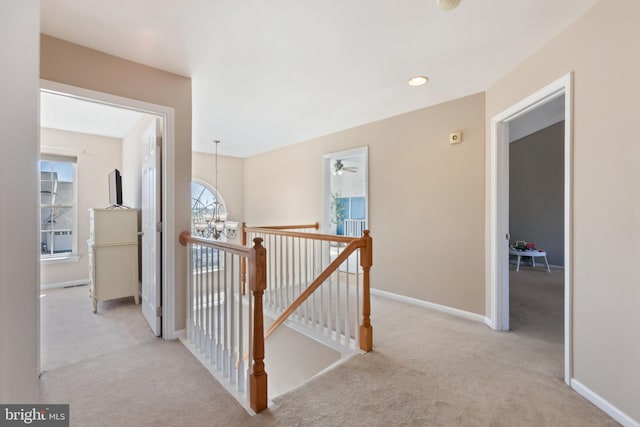 hallway with an upstairs landing, recessed lighting, baseboards, and carpet floors