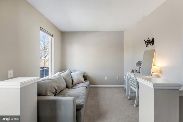 living area featuring light colored carpet and baseboards