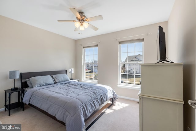 bedroom featuring light carpet, ceiling fan, and baseboards