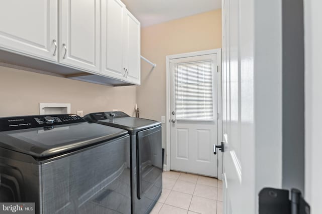 laundry room featuring light tile patterned floors, cabinet space, and separate washer and dryer