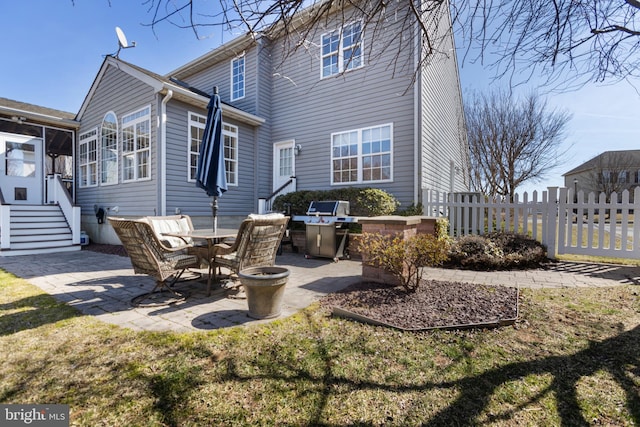 back of property featuring a patio, fence, and a sunroom