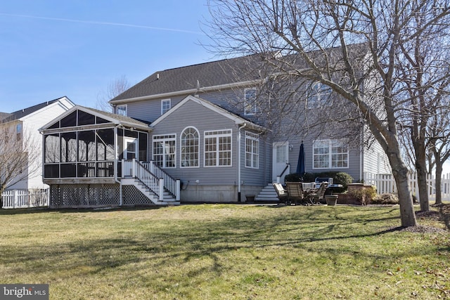 rear view of property featuring entry steps, a yard, and a sunroom