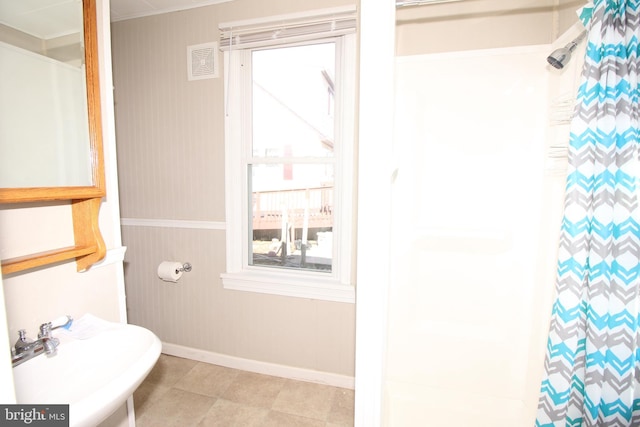 full bathroom with curtained shower, baseboards, and a sink