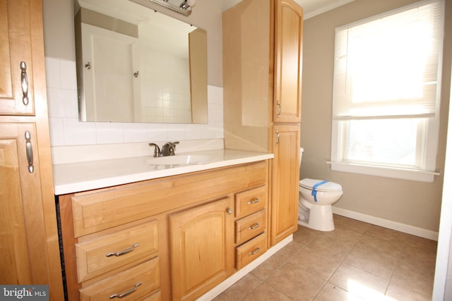 bathroom featuring vanity, toilet, baseboards, and tile patterned flooring