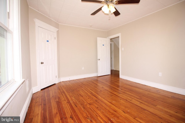 unfurnished bedroom featuring baseboards, wood-type flooring, and ceiling fan