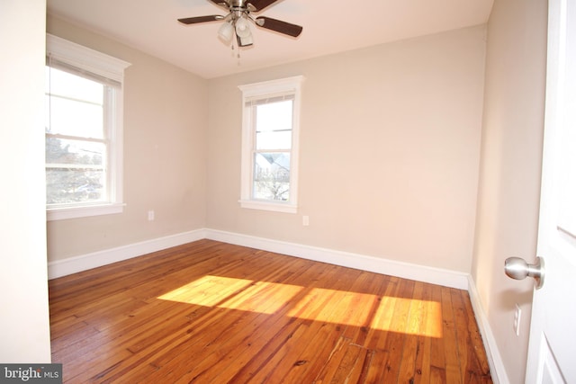 empty room featuring baseboards, wood-type flooring, and ceiling fan