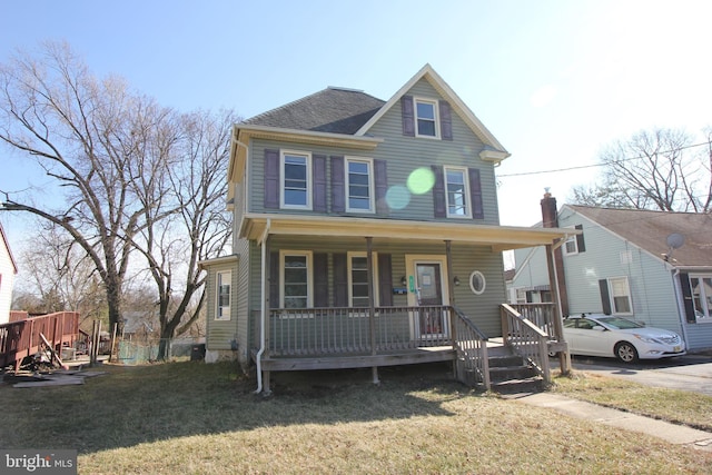 view of front of home featuring covered porch, a front yard, and roof with shingles