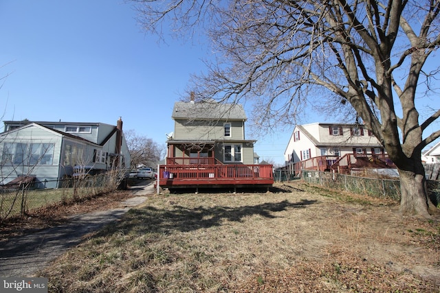 back of property featuring fence private yard, a deck, and a lawn