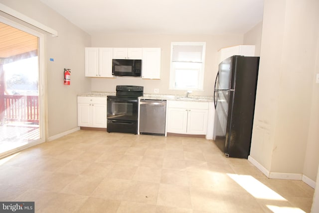 kitchen featuring white cabinetry, black appliances, baseboards, and a sink