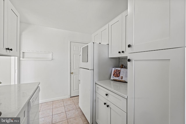 kitchen featuring white appliances, light tile patterned floors, light stone countertops, baseboards, and white cabinetry