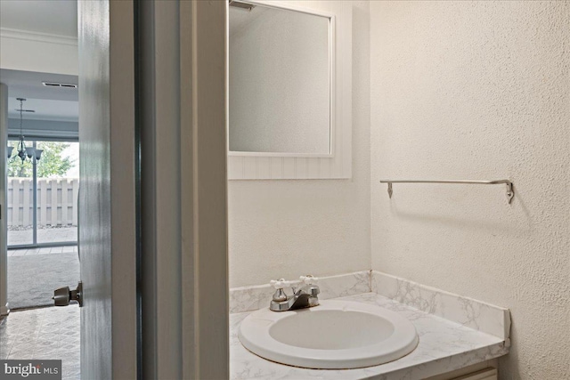 bathroom with vanity and a textured wall