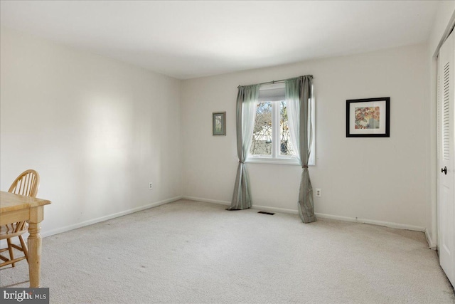 carpeted empty room with visible vents and baseboards