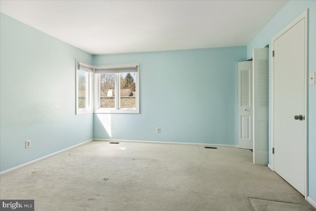 unfurnished bedroom with visible vents, carpet, and baseboards