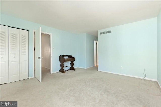 unfurnished bedroom with visible vents, baseboards, a closet, and carpet flooring