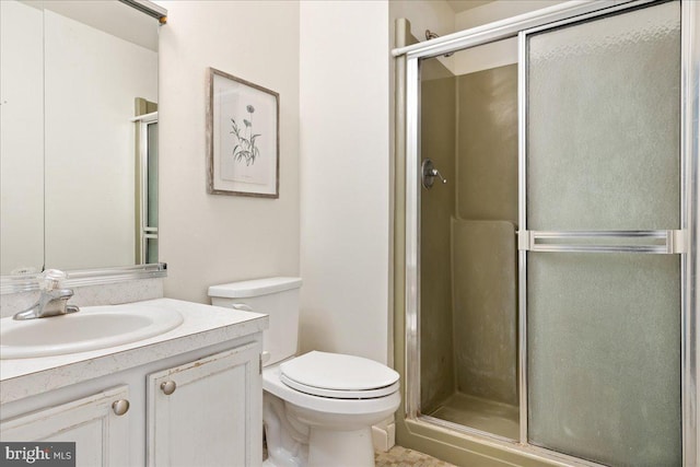 full bathroom featuring a stall shower, toilet, and vanity