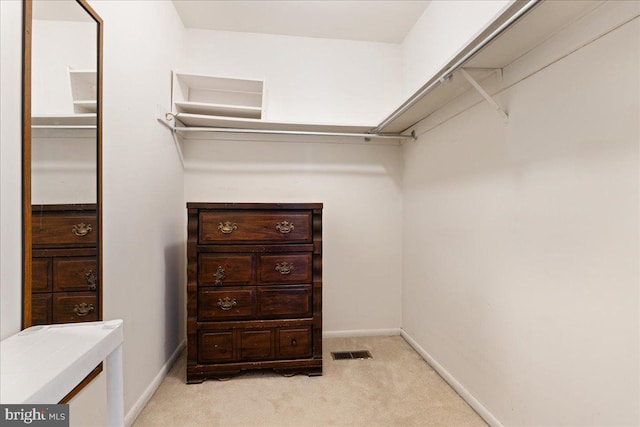 walk in closet featuring visible vents and light colored carpet