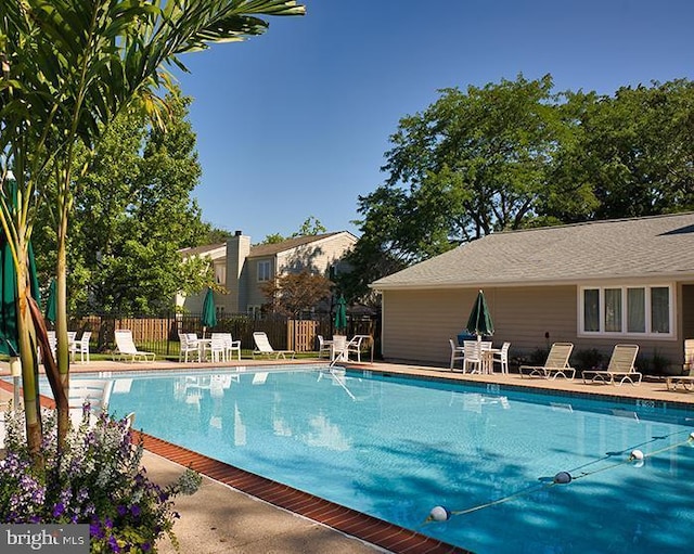 pool with a patio and fence